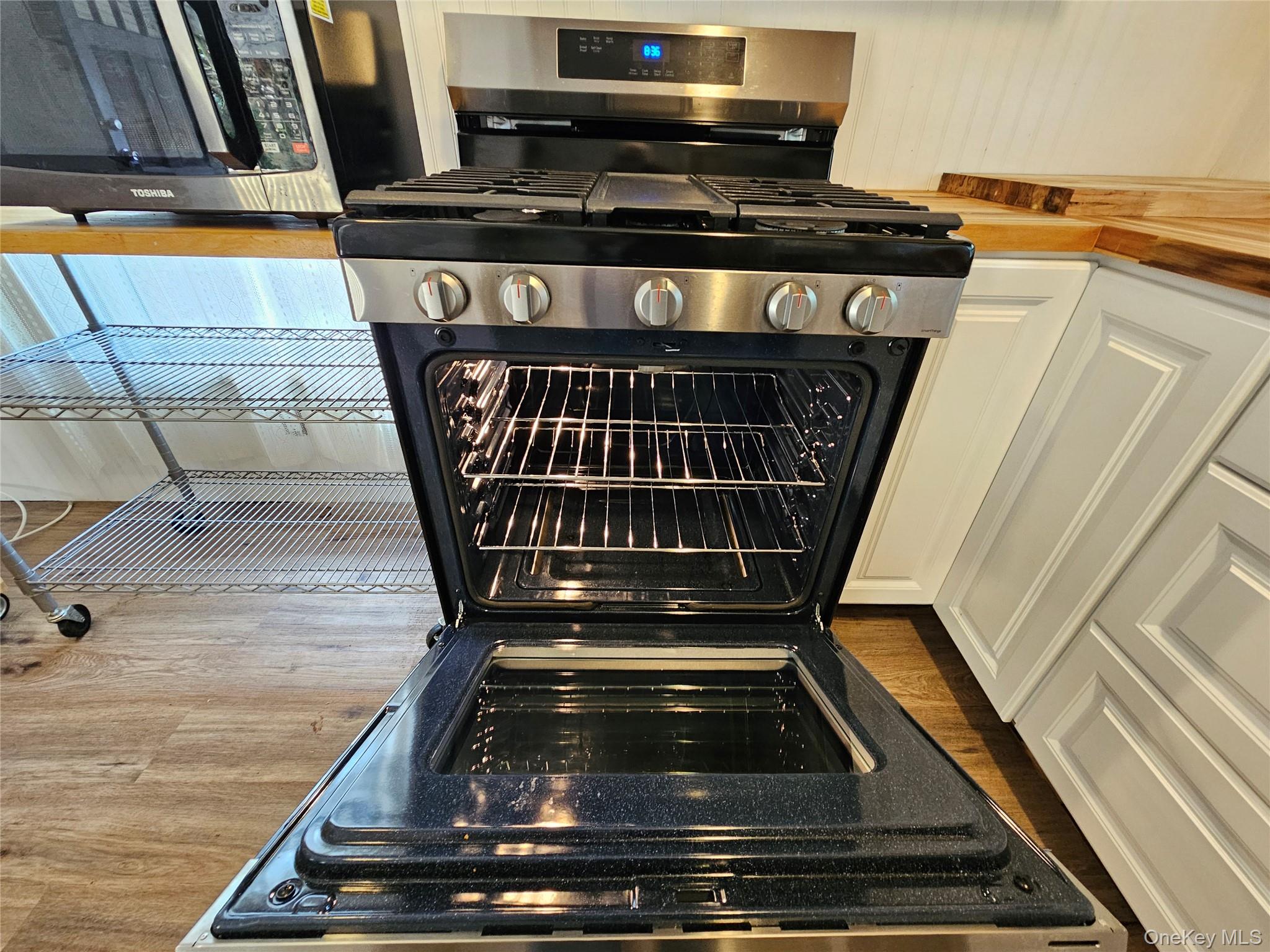 1964-106 River Road, Unit 106 Calverton, NY 11933 - Photo 8 of 26 a stove top oven sitting inside of a kitchen