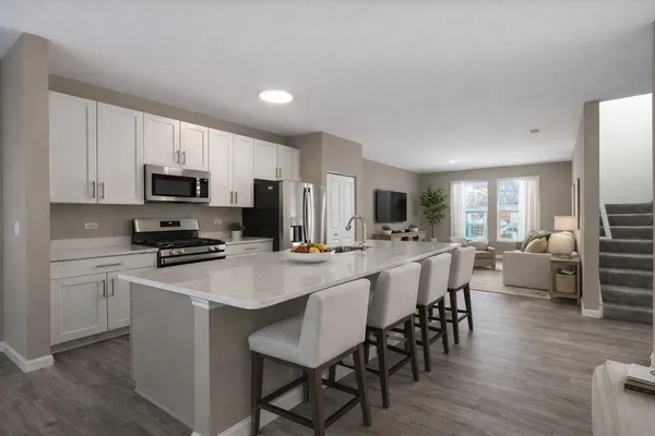 a kitchen with stainless steel appliances a microwave sink refrigerator dining table and chairs