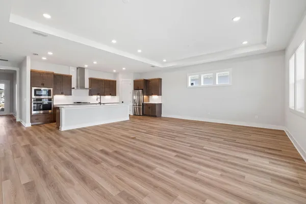 a view of kitchen with kitchen island wooden cabinets and refrigerator