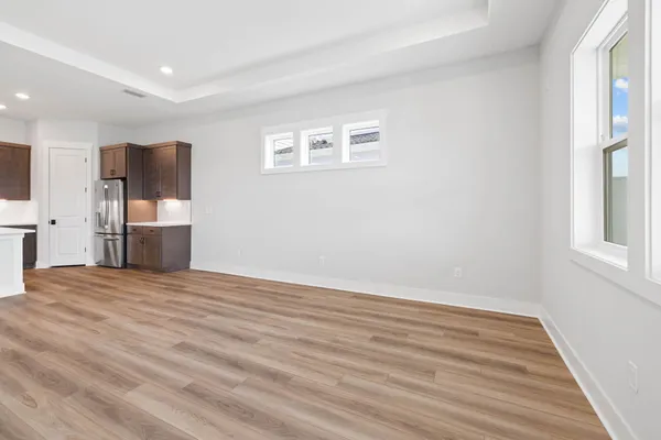 a view of empty room with wooden floor and window