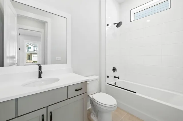 a bathroom with a bathtub shower sink vanity and toilet