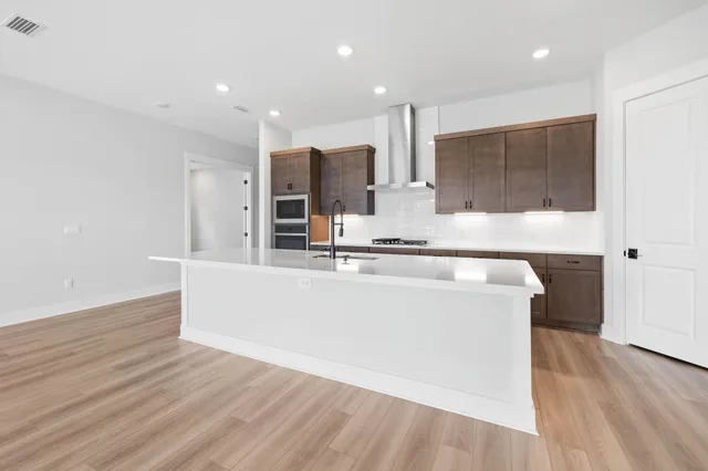 a kitchen with stainless steel appliances a refrigerator and a stove top oven