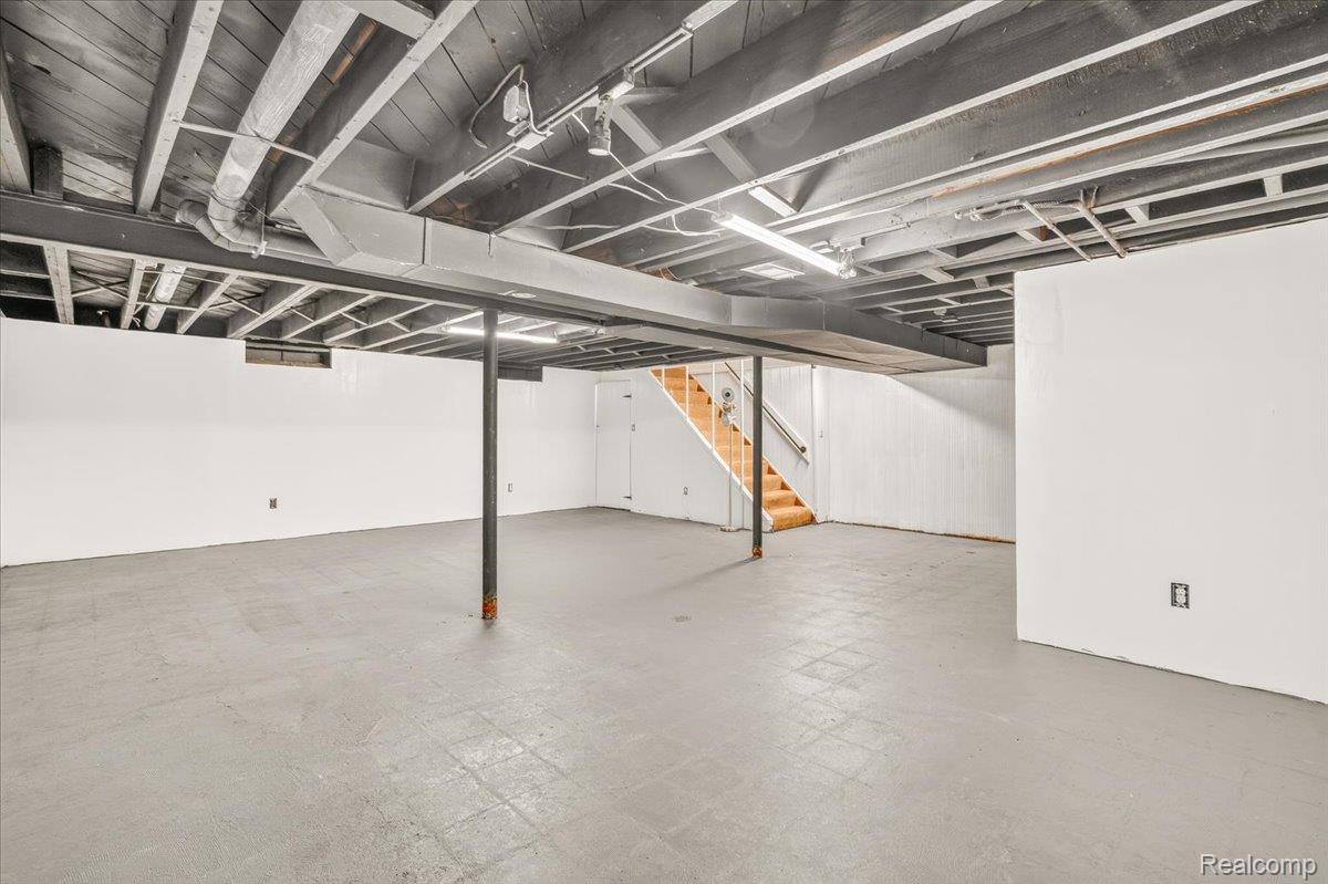 11802 Columbia Street Redford, MI 48239 - Photo 25 of 39 Expansive finished lower level featuring finished concrete flooring, drywall, and a painted exposed ceiling with overhead lighting.
