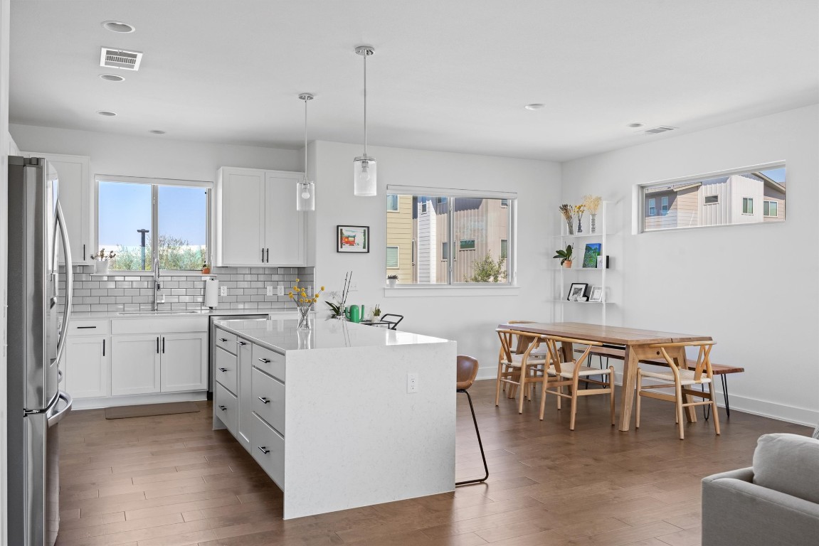 5315 La Crosse Avenue, Unit 18 Austin, TX 78739 - Photo 12 of 40 Kitchen with white cabinets, freestanding refrigerator, hanging light fixtures, backsplash, and recessed lighting