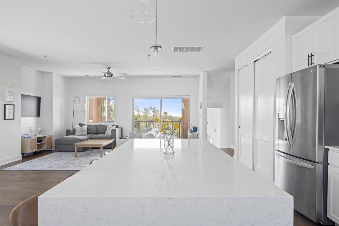 5315 La Crosse Avenue, Unit 18 Austin, TX 78739 - Photo 14 of 40 Kitchen featuring stainless steel refrigerator with ice dispenser, white cabinetry, and light stone countertops