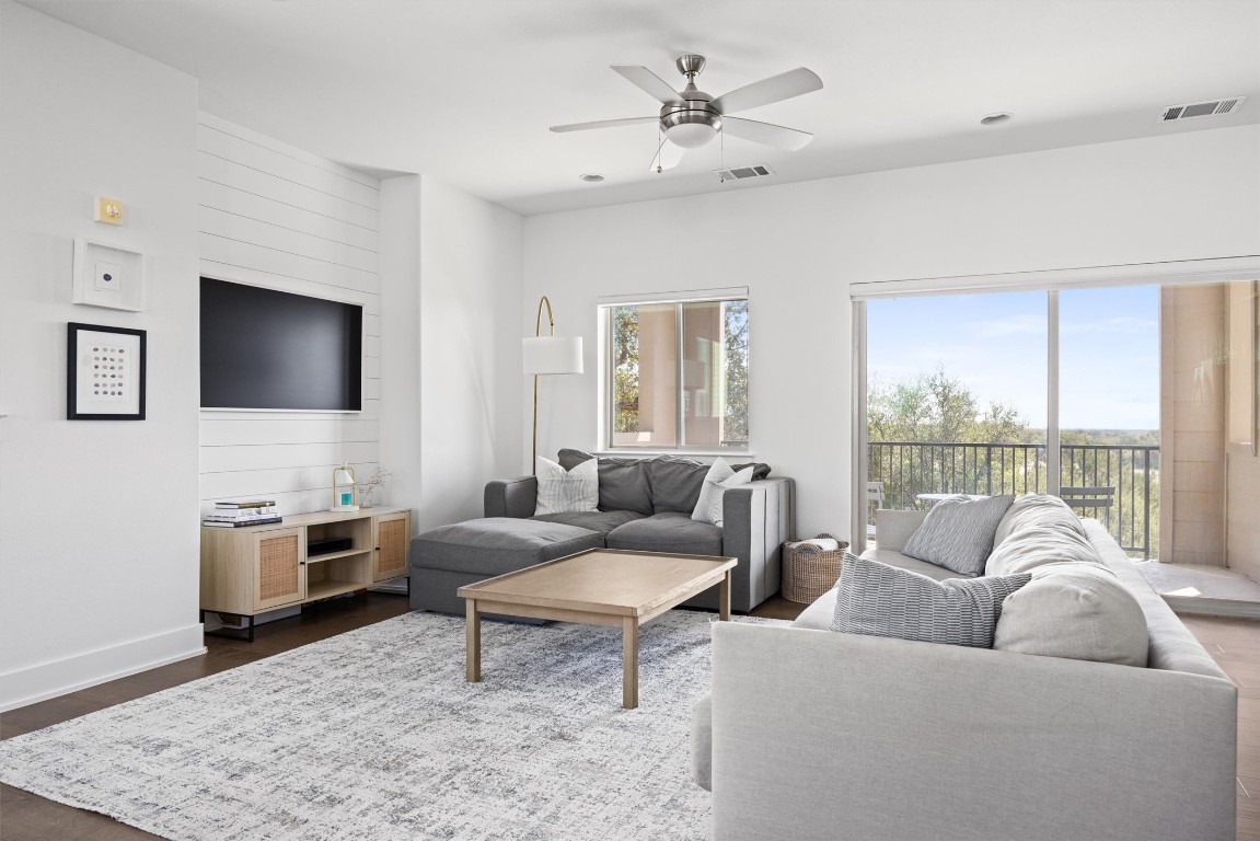 5315 La Crosse Avenue, Unit 18 Austin, TX 78739 - Photo 9 of 40 Living room featuring dark wood-style floors, ceiling fan, and accent walls