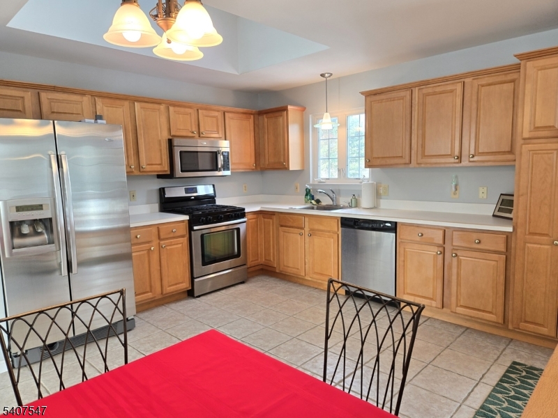 63 Halsey Road Newton, NJ 07860 - Photo 6 of 35 a kitchen with stainless steel appliances granite countertop a microwave a stove a sink dishwasher a refrigerator with white cabinets and wooden floor