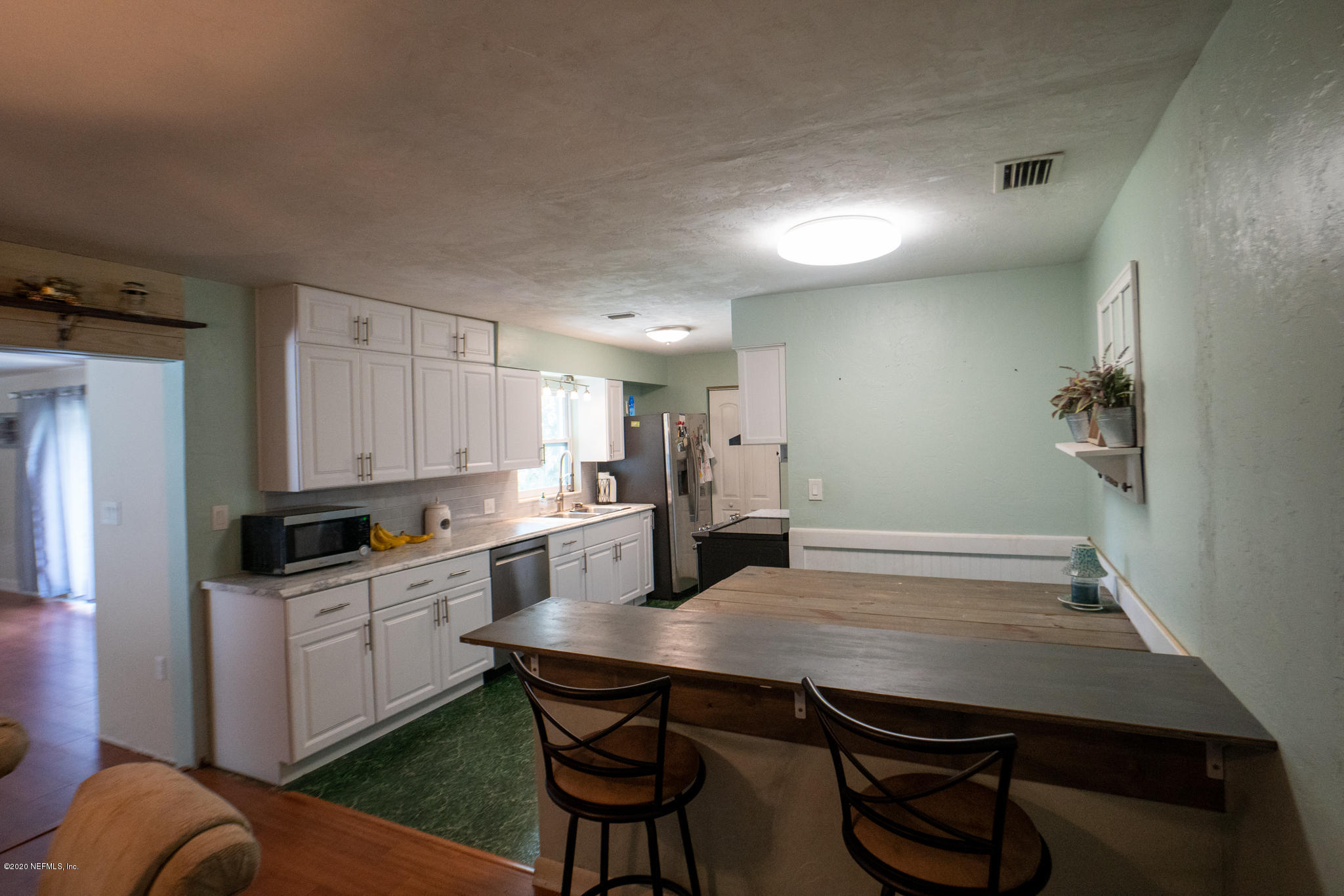 655 Pointview Road Keystone Heights, FL 32656 - Photo 10 of 38 a kitchen with a table chairs refrigerator and cabinets
