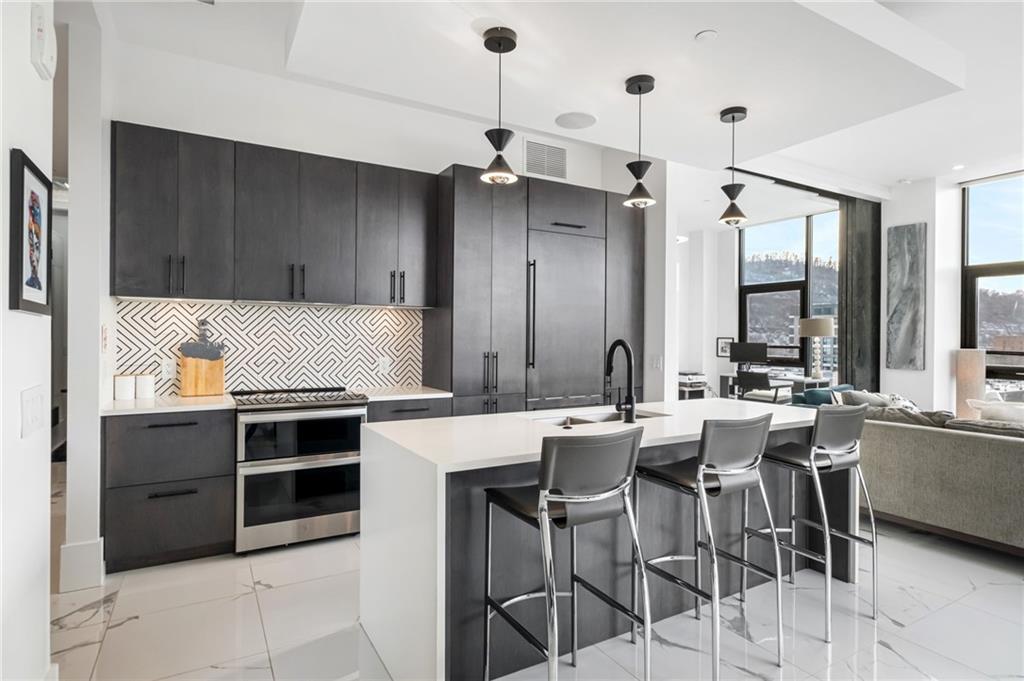 2554 Smallman Street, Unit 501 Pittsburgh, PA 15222 - Photo 7 of 45 a kitchen with stainless steel appliances a stove a sink island and a refrigerator