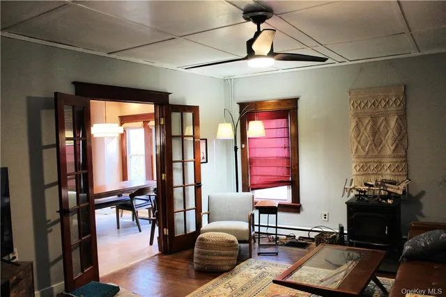 a living room with furniture two window and wooden floor
