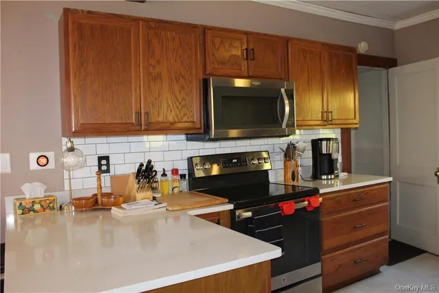 a kitchen with microwave a stove and cabinets
