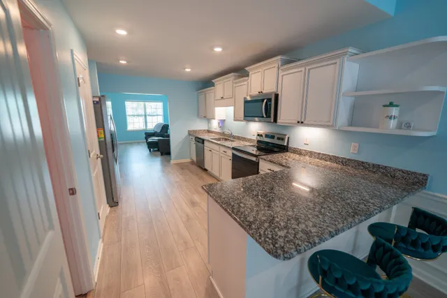 a kitchen with stainless steel appliances granite countertop a refrigerator and a sink