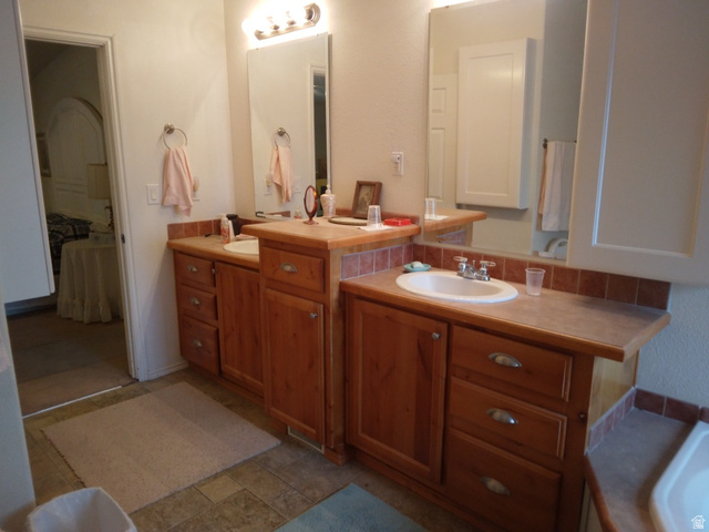 1603 South Campground Road, Unit 107 Beaver, UT 84713 - Photo 6 of 11 Dual vanity with wood-finish cabinetry, integrated sinks, and tiled backsplashes