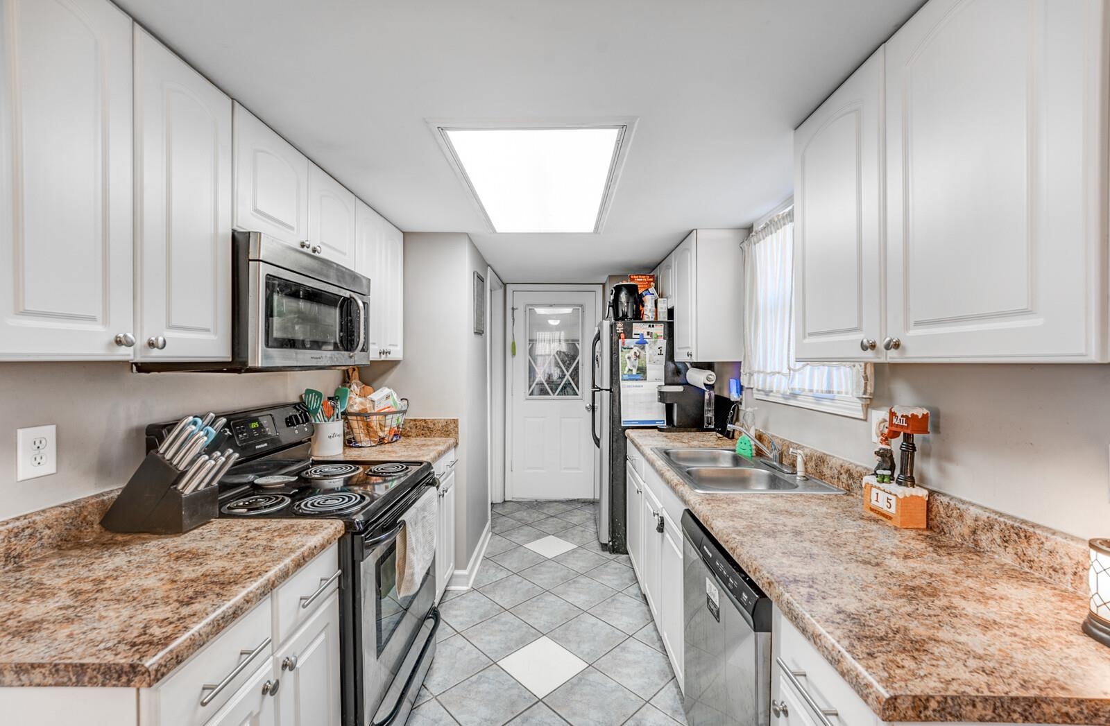 10 Raphael Cove Munford, TN 38058 - Photo 7 of 23 a kitchen with granite countertop a sink a stove oven and wooden cabinets