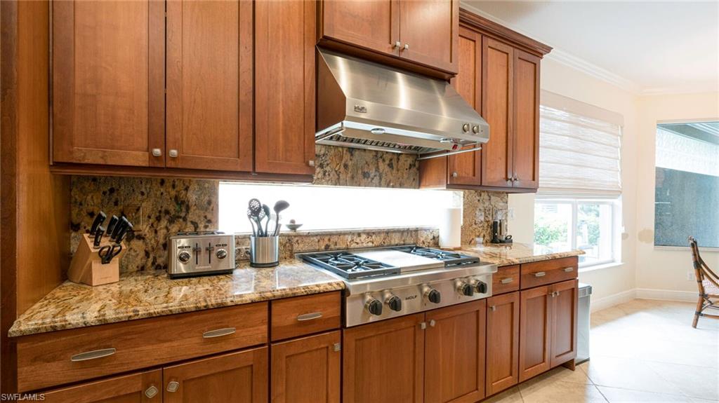 7667 Martino Circle Naples, FL 34112 - Photo 11 of 41 a kitchen with stainless steel appliances granite countertop a sink stove and cabinets