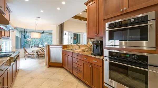 a kitchen with stainless steel appliances kitchen island granite countertop a stove a sink and a microwave