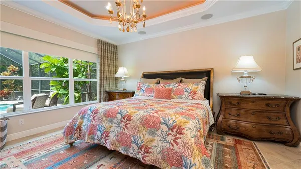 a bedroom with a bed a chandelier and a window