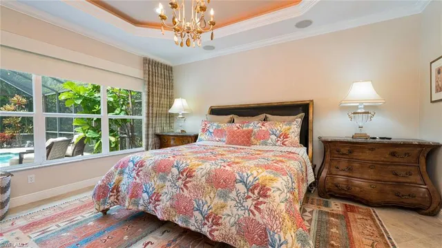 a bedroom with a bed a chandelier and a window
