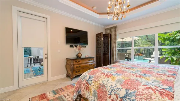 a bedroom with a bed a flat screen tv and a window