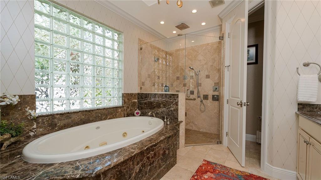 7667 Martino Circle Naples, FL 34112 - Photo 20 of 41 a bathroom with a tub and shower