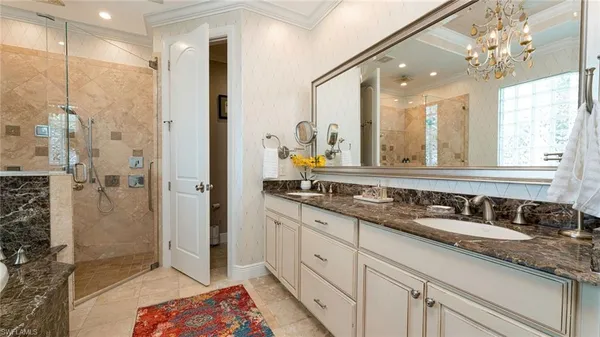 a bathroom with a double vanity sink mirror and shower