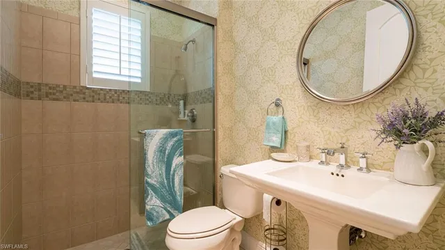 a bathroom with a sink a mirror a toilet and a mirror