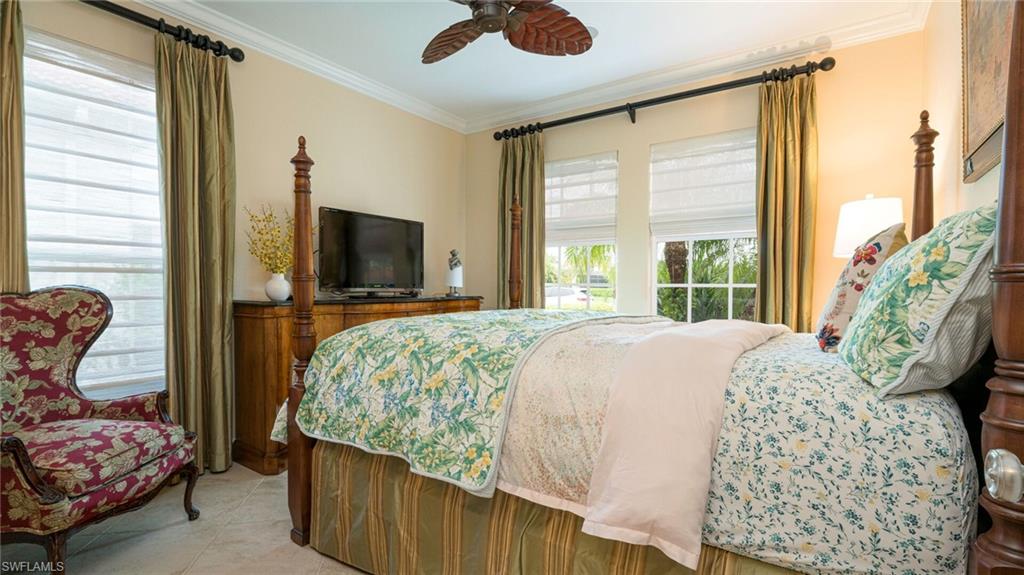 7667 Martino Circle Naples, FL 34112 - Photo 25 of 41 a bedroom with a bed and glass walk in closet