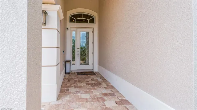 a view of a hallway with wooden floor and a white door