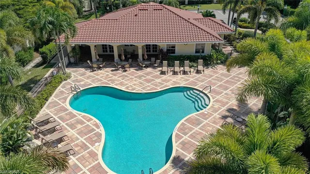 a view of a house with pool and chairs
