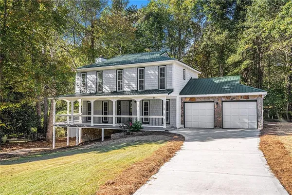 a front view of house with yard and trees in the background