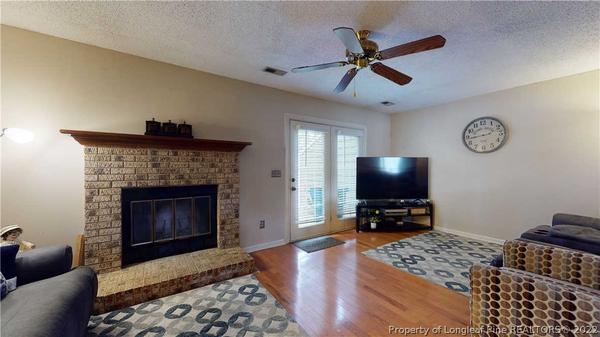 4604 Pine Trace Drive Raleigh, NC 27613 - Photo 12 of 30 a living room with furniture a flat screen tv and a fireplace