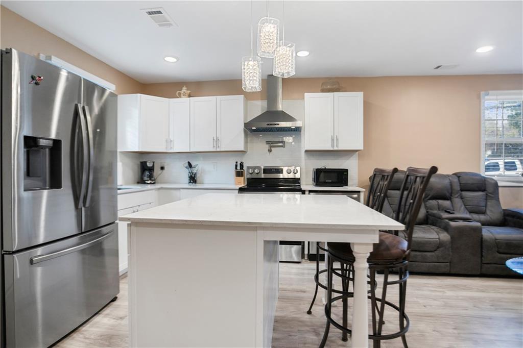 a kitchen with stainless steel appliances a refrigerator a stove a sink and a island