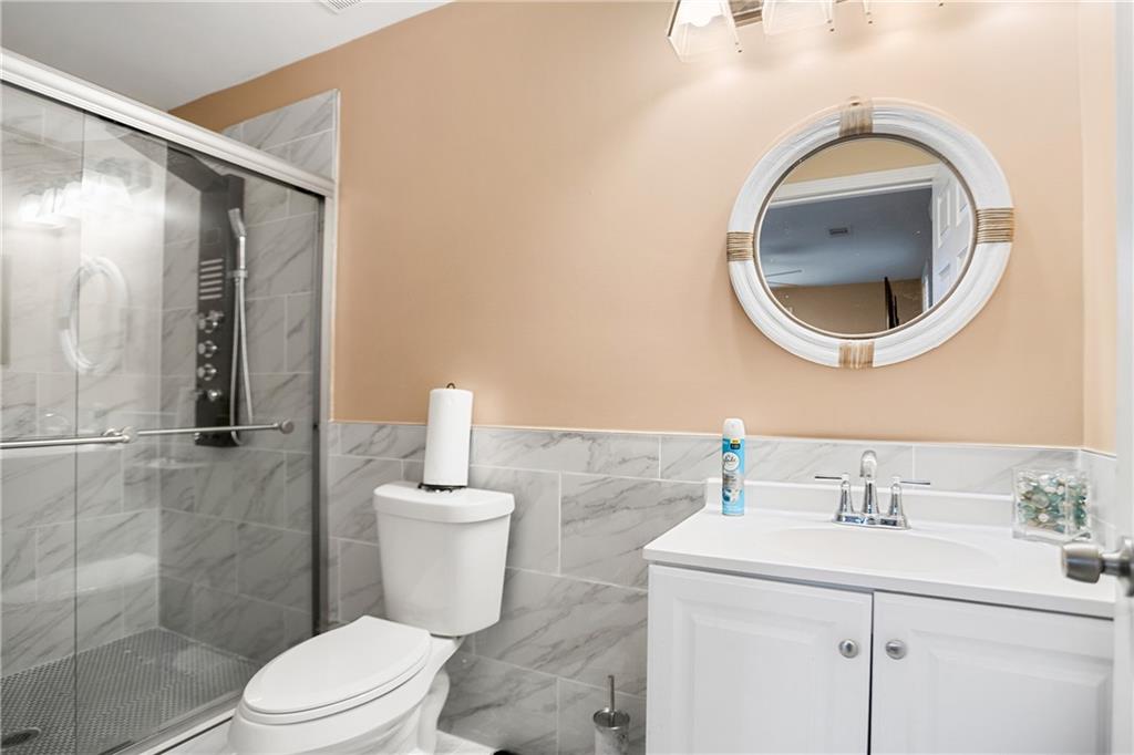 142 Hutton Place Northwest Atlanta, GA 30318 - Photo 7 of 14 a bathroom with a sink a toilet and a mirror