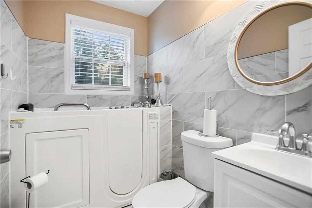 142 Hutton Place Northwest Atlanta, GA 30318 - Photo 9 of 14 a bathroom with a sink toilet and a mirror