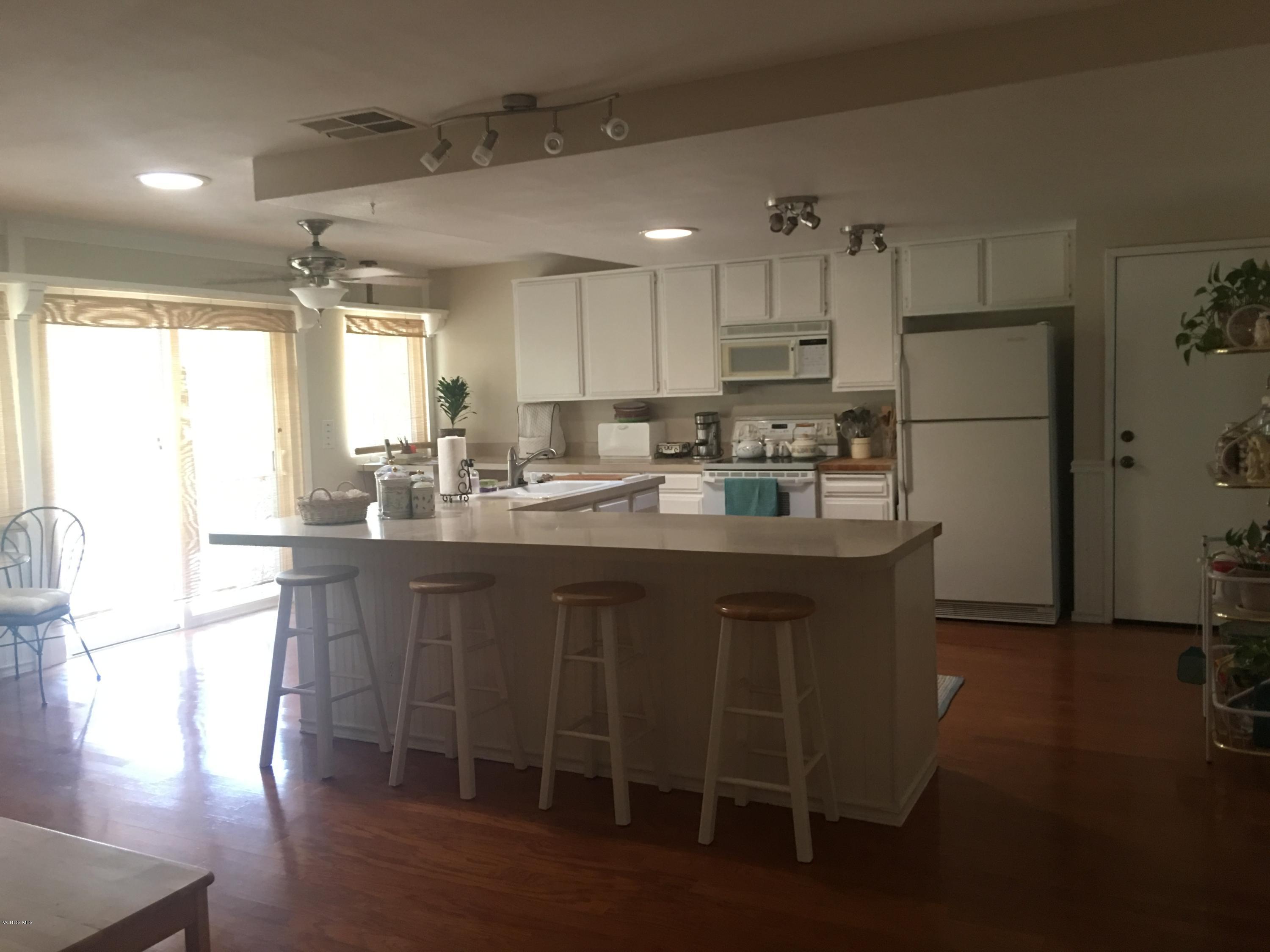 718 Tranquil Lane Simi Valley, CA 93065 - Photo 9 of 68 a kitchen with kitchen island granite countertop a sink cabinets and wooden floor