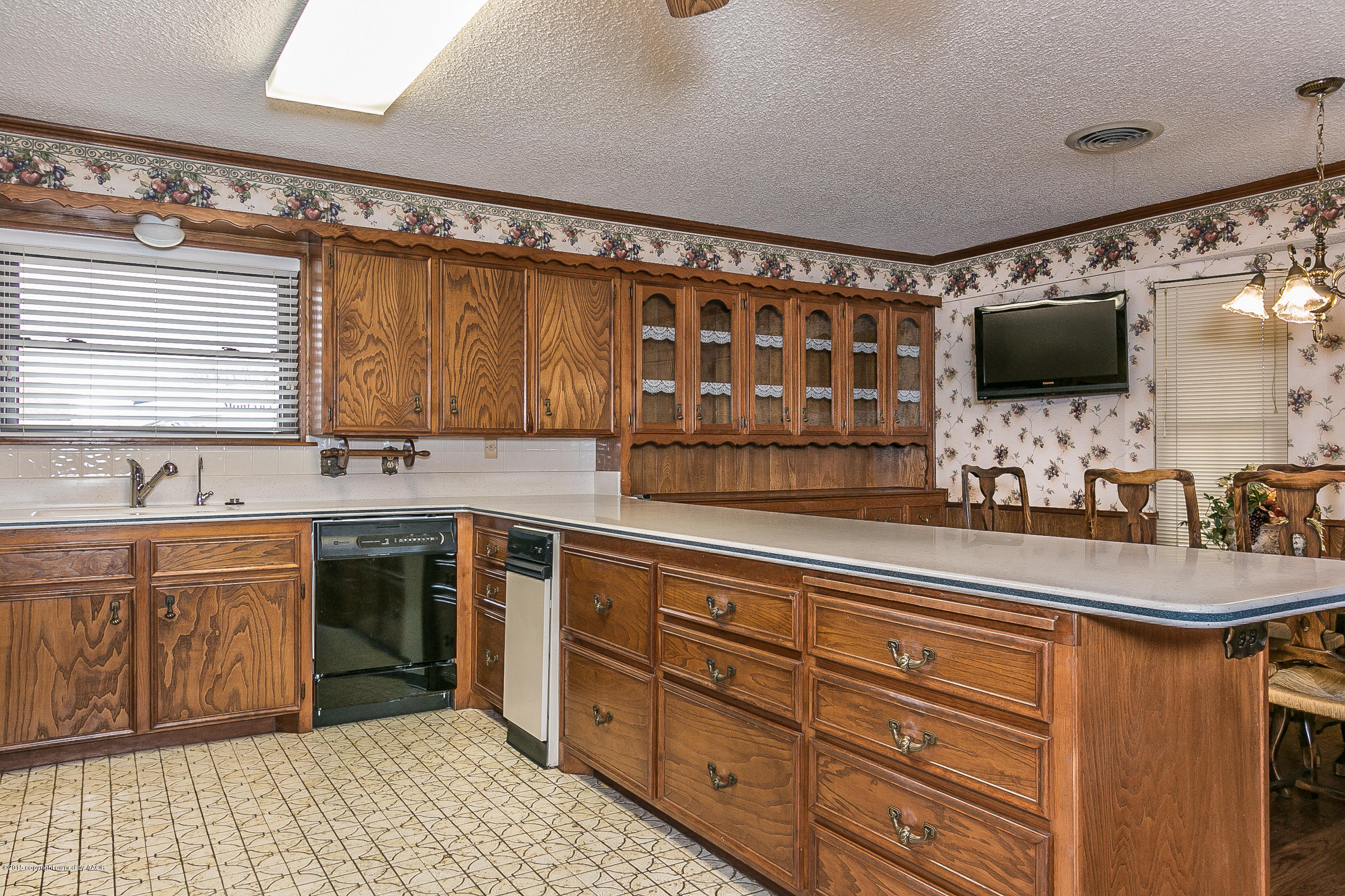 8117 Santa Fe Trail Amarillo, TX 79110 - Photo 11 of 27 a kitchen with sink cabinets and flat screen tv
