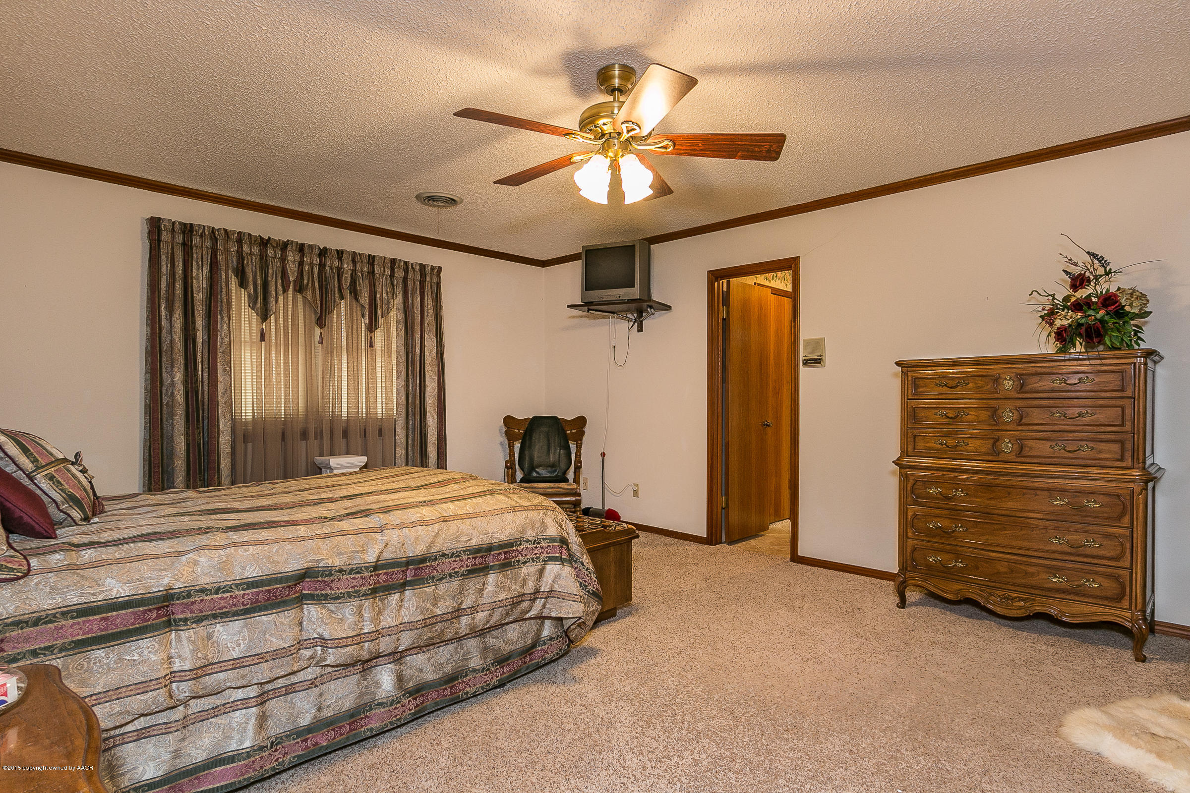 8117 Santa Fe Trail Amarillo, TX 79110 - Photo 14 of 27 a bedroom with a bed and a chandelier