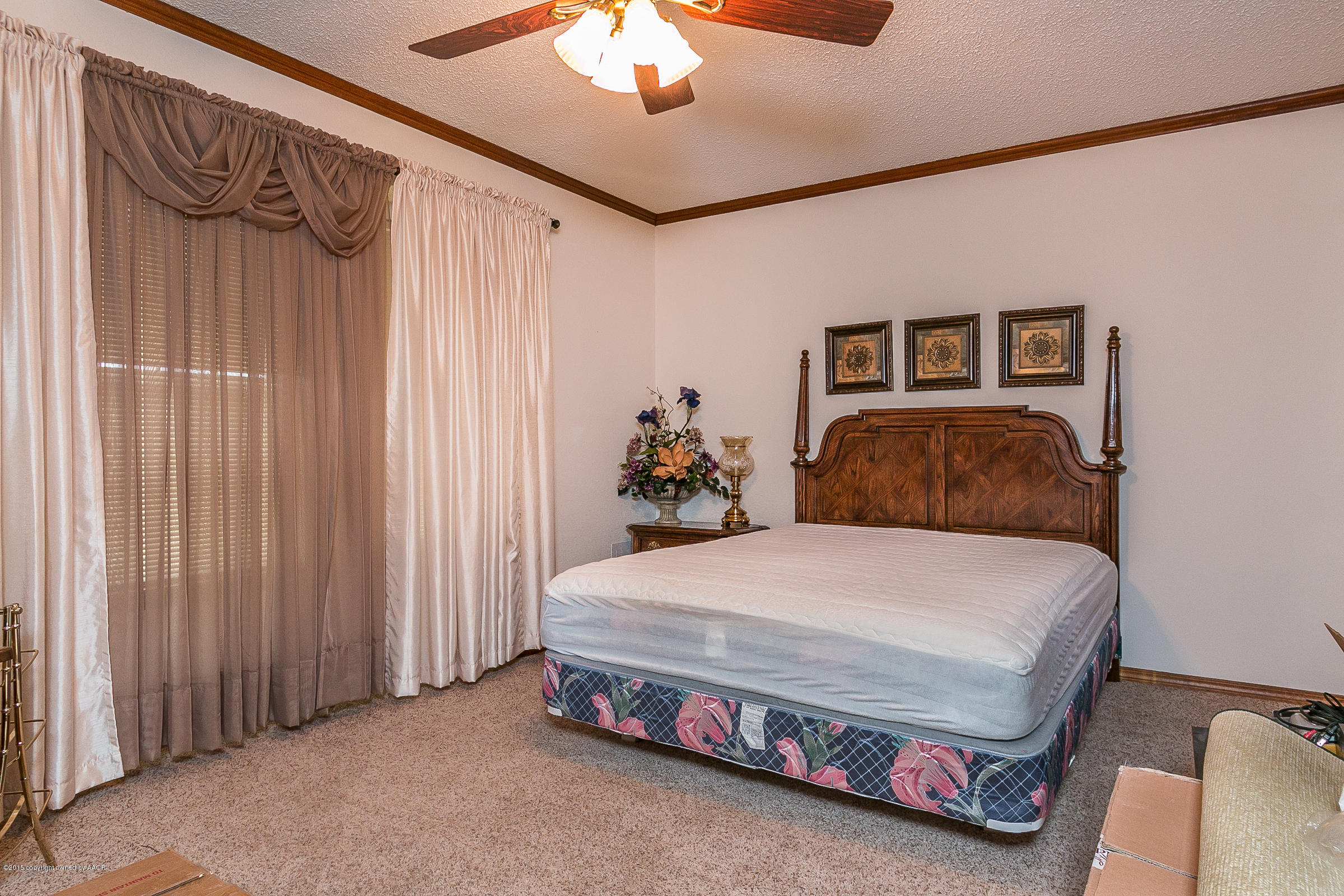 8117 Santa Fe Trail Amarillo, TX 79110 - Photo 18 of 27 a bedroom with a bed and a chandelier