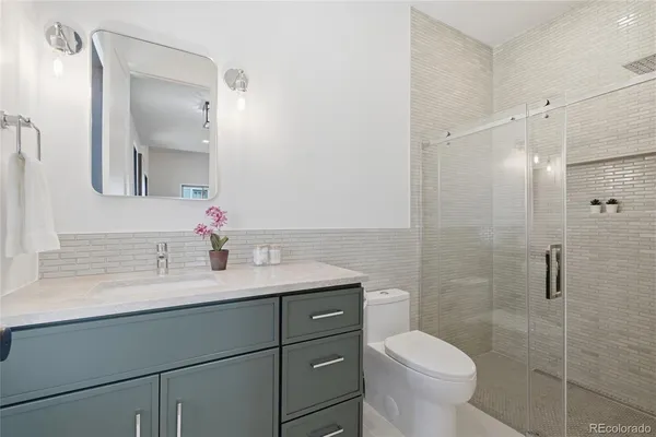 a bathroom with a sink toilet vanity and shower