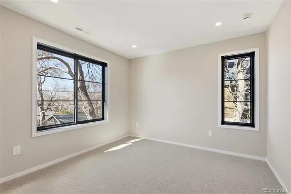 an empty room with windows and closet