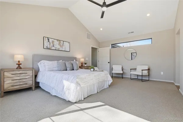 a spacious bedroom with a bed and a chandelier