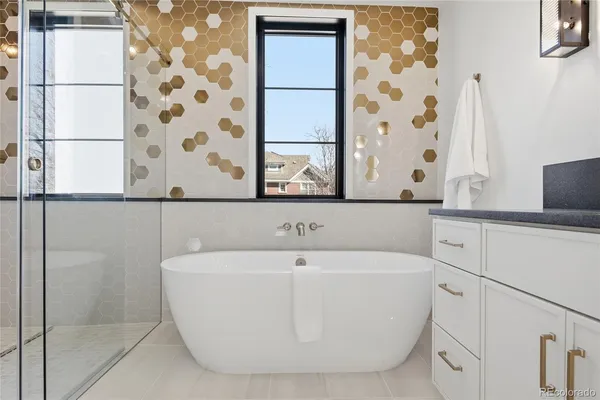 a white bath tub sitting next to a white sink and a shower