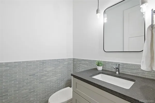a bathroom with a granite countertop sink and a mirror