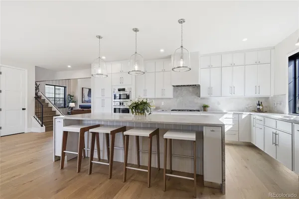 a kitchen with a white cabinets and chairs