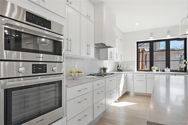 a kitchen with stainless steel appliances granite countertop white cabinets a sink and dishwasher