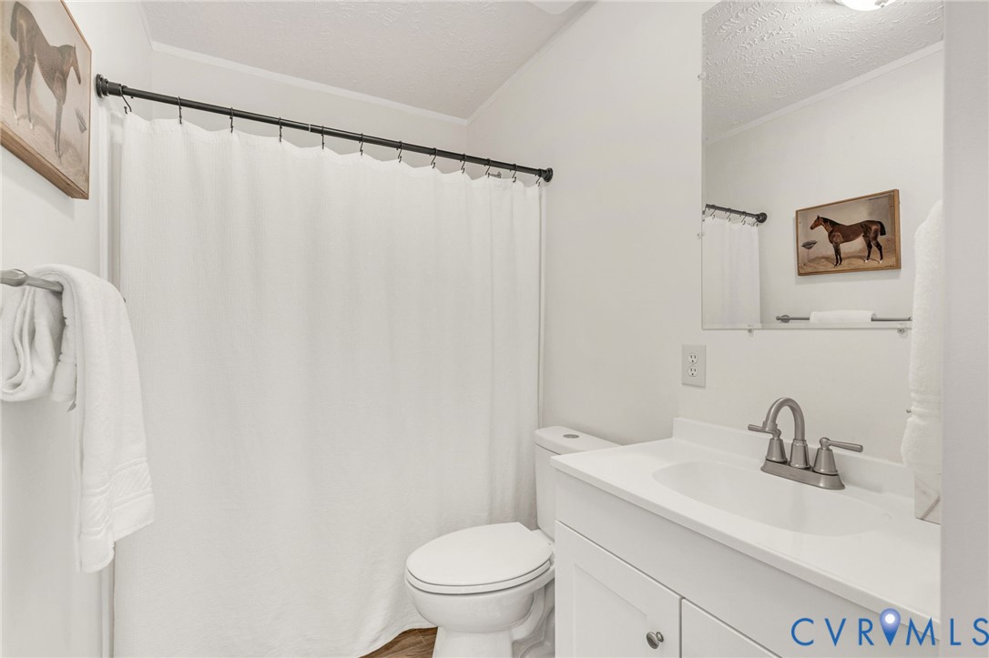 9424 Marlfield Road Gloucester, VA 23061 - Photo 26 of 31 a bathroom with a sink a toilet and a mirror