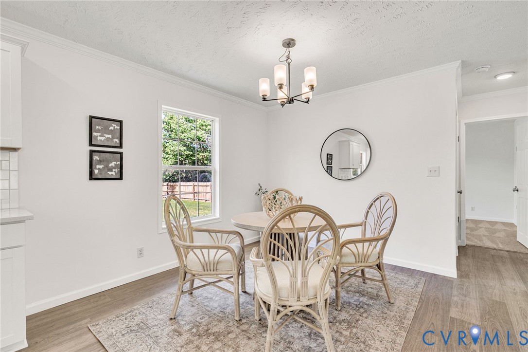 9424 Marlfield Road Gloucester, VA 23061 - Photo 8 of 31 a view of a dining room with furniture a chandelier and wooden floor