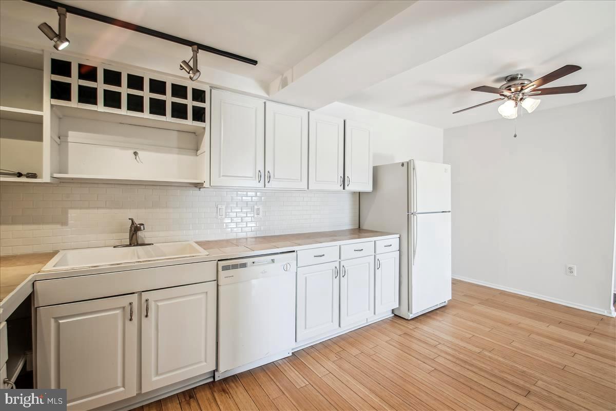 2574 Riva Road, Unit 12A Annapolis, MD 21401 - Photo 13 of 33 a kitchen with stainless steel appliances white cabinets and wooden floors