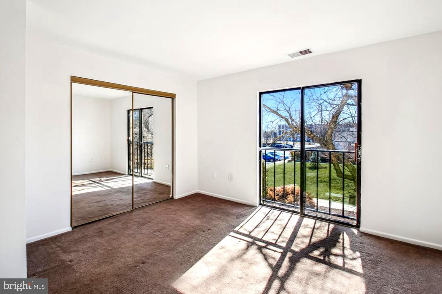 2574 Riva Road, Unit 12A Annapolis, MD 21401 - Photo 18 of 33 an empty room with floor to ceiling windows and wooden floor