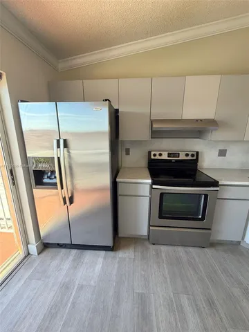 a kitchen with a refrigerator stove and cabinets
